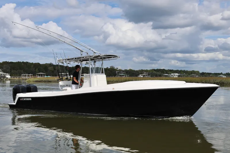 Slide: The Image of 2005 Contender 31 Cuddy boat interior with white seating, on calm water. - 7