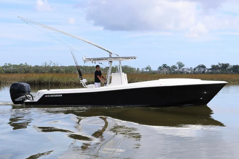 Slide: The Image of 2005 Contender 31 Cuddy boat on open water, featuring a sleek design and spacious deck. - 9