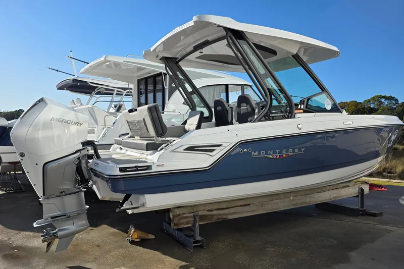 Slide: The Image of 2026 Monterey Elite 25 OB boat with Mercury outboard engine, docked on a sunny day. - 1