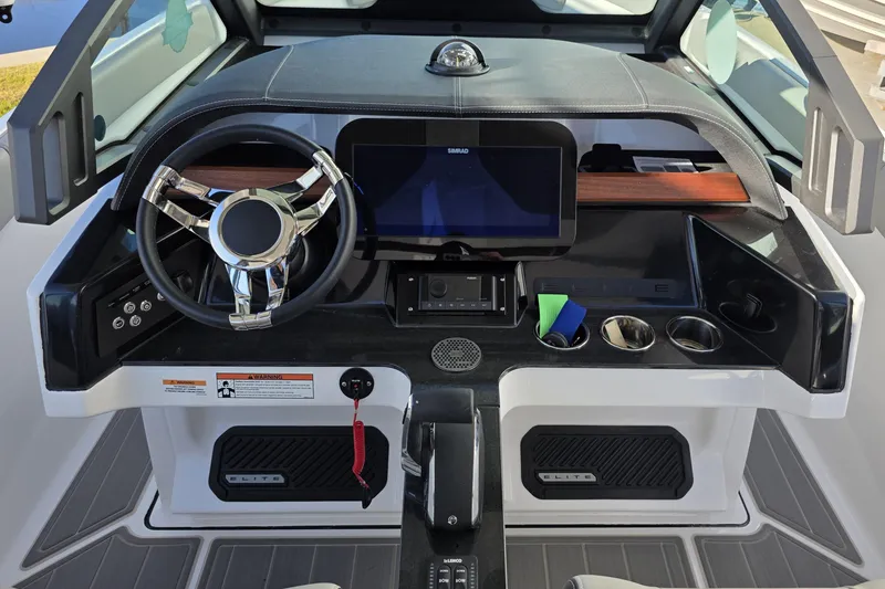 Slide: The Image of 2026 Monterey Elite 25 OB boat dashboard with steering wheel and digital display. - 12
