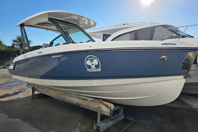 Slide: The Image of 2026 Monterey Elite 25 OB boat on display, featuring sleek design and award emblem. - 2