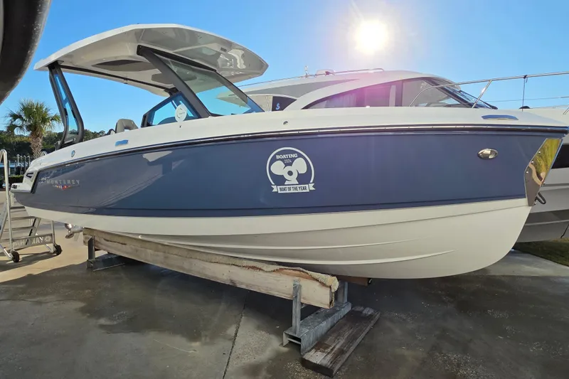 Slide: The Image of 2026 Monterey Elite 25 OB boat displayed outdoors under bright sunlight. - 4