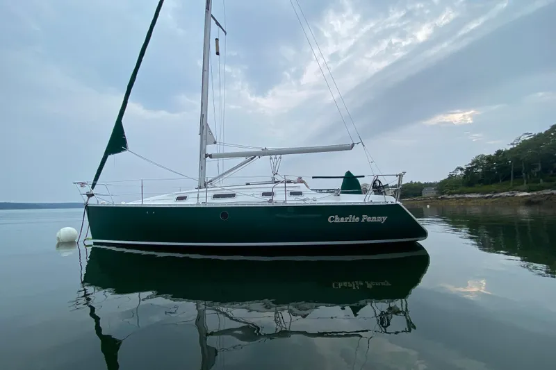 The Image of 1994 Beneteau Oceanis 300 sailboat on calm water, overcast sky background. - 1