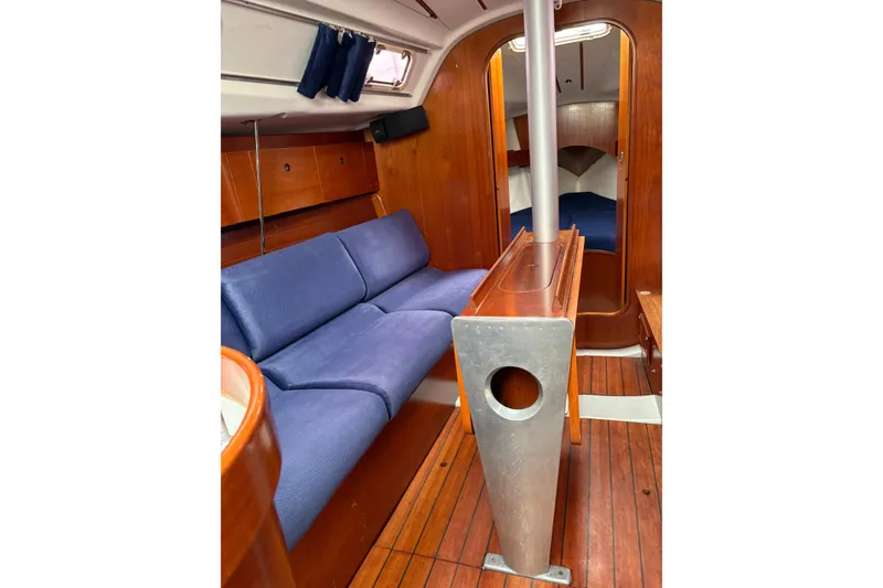Slide: The Image of Interior of 1994 Beneteau Oceanis 300 sailboat with blue seating and wooden finishes. - 18