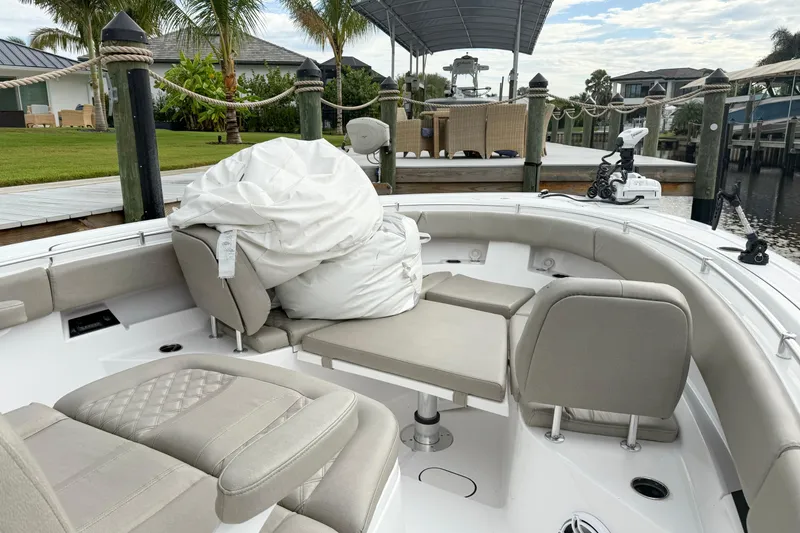 Slide: The Image of 2023 Sportsman Open 322 Center Console boat interior with seating and dock view. - 10