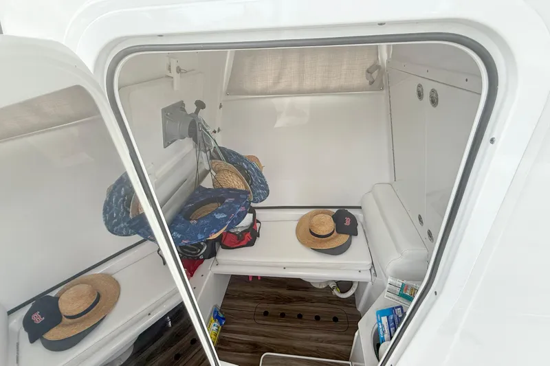 Slide: The Image of 2023 Sportsman Open 322 Center Console cabin interior with hats and accessories. - 12