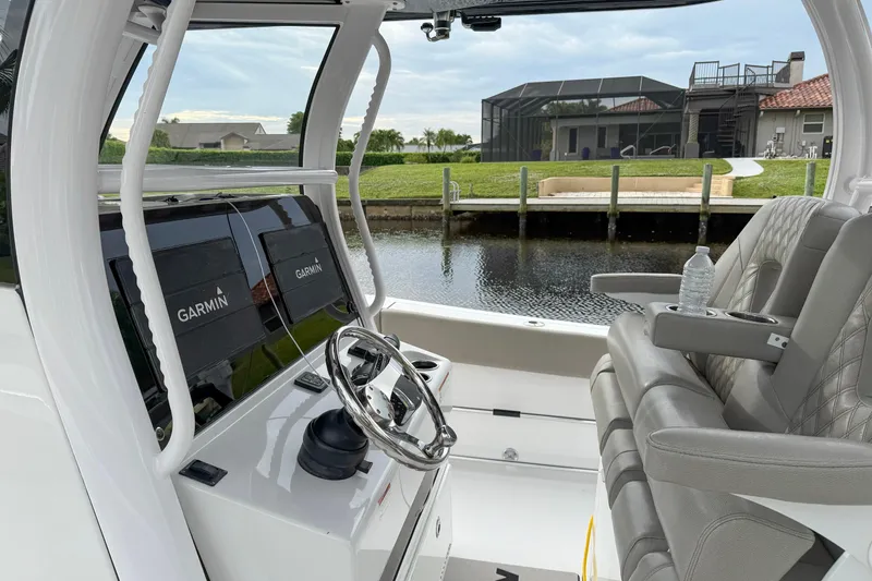 Slide: The Image of 2023 Sportsman Open 322 Center Console boat interior with Garmin displays and leather seating. - 2