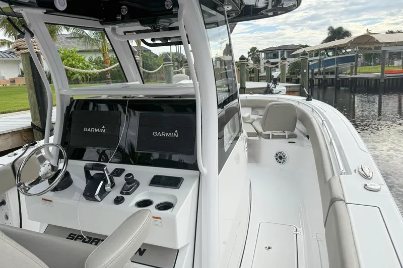 Slide: The Image of 2023 Sportsman Open 322 Center Console boat with Garmin navigation, docked by a waterfront. - 3