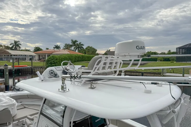 Slide: The Image of 2023 Sportsman Open 322 Center Console boat with Garmin radar, docked under cloudy skies. - 4