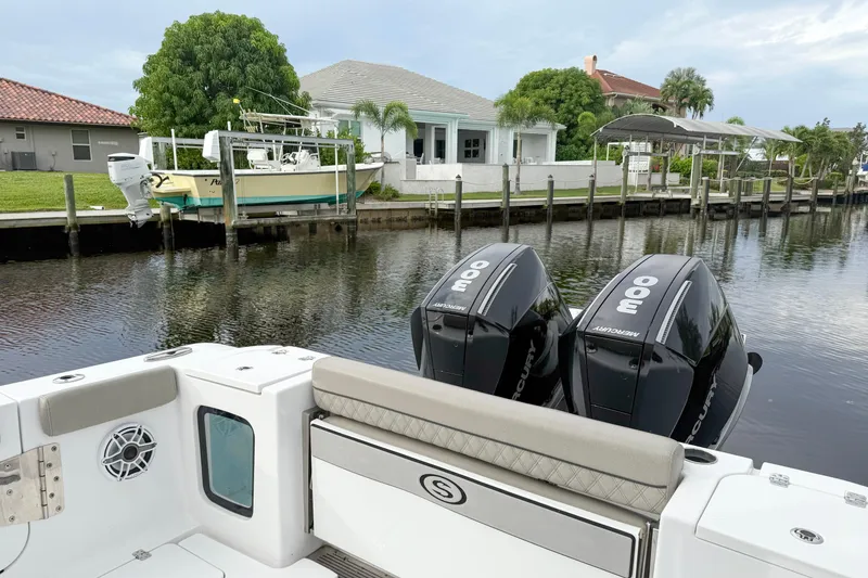 Slide: The Image of 2023 Sportsman Open 322 Center Console with twin Mercury engines docked by waterfront homes. - 7