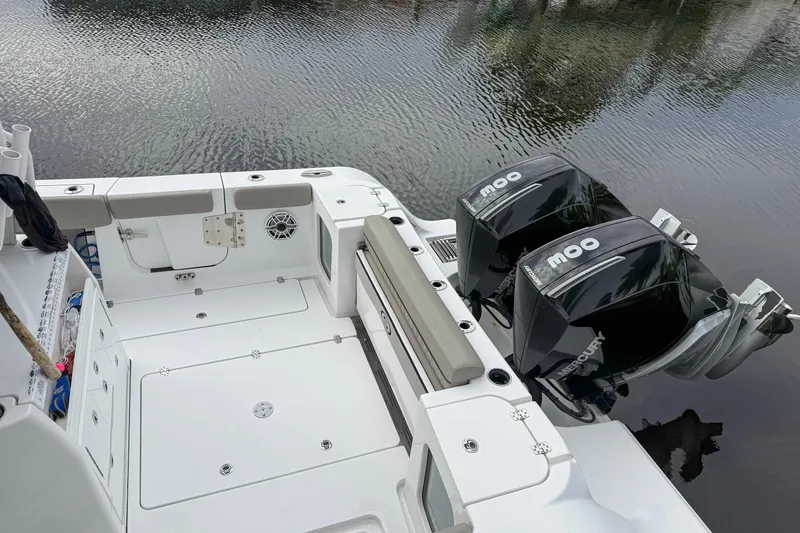 Slide: The Image of 2023 Sportsman Open 322 Center Console boat with dual Mercury outboard engines on calm water. - 8