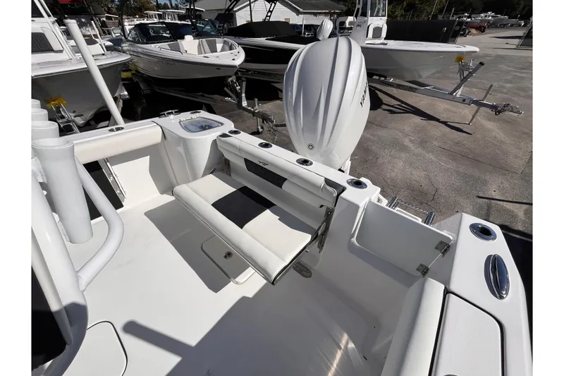 Slide: The Image of 2026 Tidewater 232 CC Adventure boat interior with seating and motor, displayed outdoors. - 5