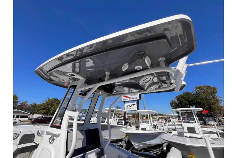 Slide: The Image of 2026 Tidewater 232 CC Adventure boat with T-top and electronics, displayed outdoors. - 8