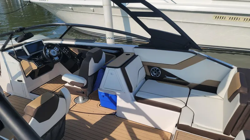 Slide: The Image of 2021 Yamaha Boats 252SD interior with sleek seating and modern design at a dock. - 18