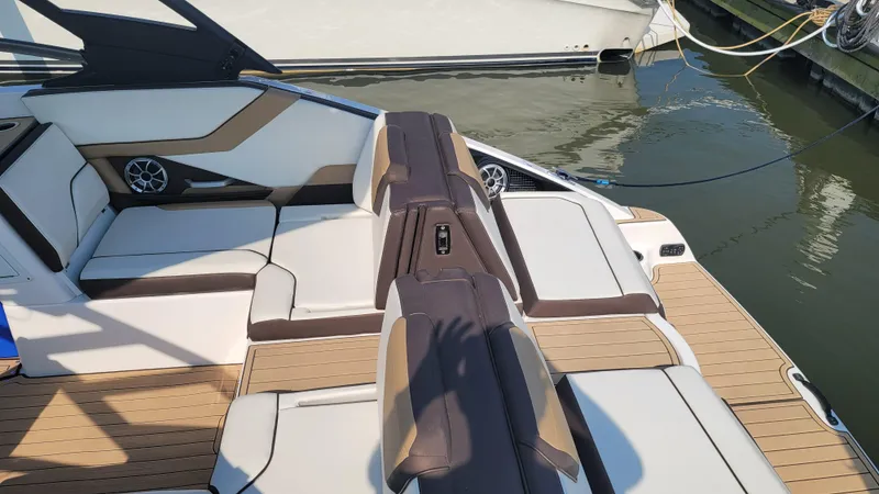 Slide: The Image of 2021 Yamaha Boats 252SD interior with sleek design, docked at marina. - 19