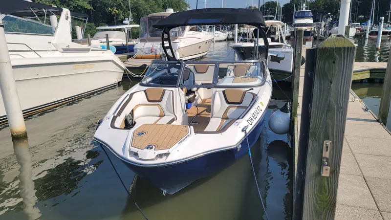 Slide: The Image of 2021 Yamaha Boats 252SD on trailer, blue and white design, parked outdoors. - 3