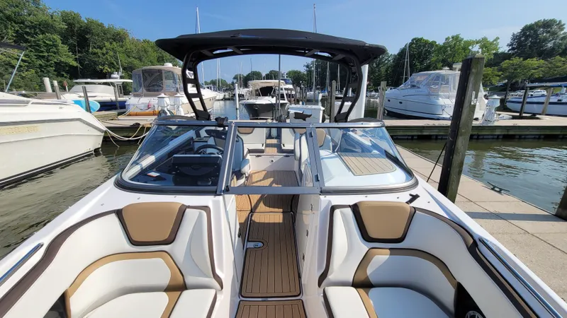 Slide: The Image of 2021 Yamaha Boats 252SD at marina, featuring sleek design and spacious seating. - 8