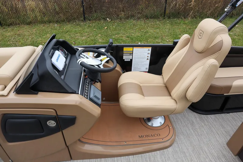 Slide: The Image of 2026 Godfrey Monaco 235 SFL boat interior with beige captain's chair and steering console. - 10