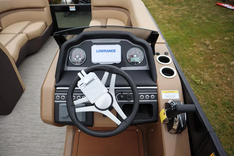 Slide: The Image of 2026 Godfrey Monaco 235 SFL boat dashboard with steering wheel and Lowrance display. - 11