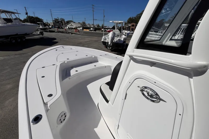Slide: The Image of 2026 Tidewater 2410 Bay Max boat, white deck, parked outdoors under clear blue sky. - 10
