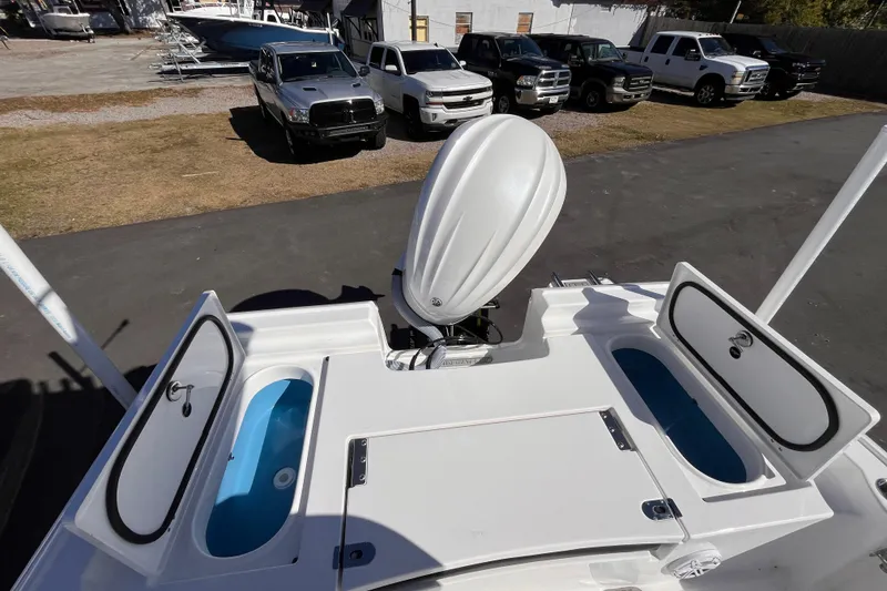 Slide: The Image of 2026 Tidewater 2410 Bay Max boat with open storage compartments and outboard motor. - 14