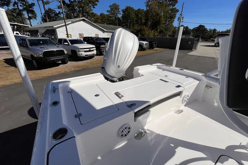 Slide: The Image of 2026 Tidewater 2410 Bay Max boat, white deck, parked outdoors with vehicles in background. - 4