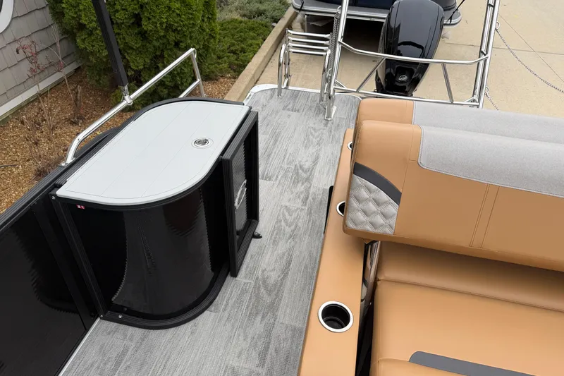 Slide: The Image of 2025 Crest Classic 220 boat interior with tan seating and sleek black storage unit. - 12