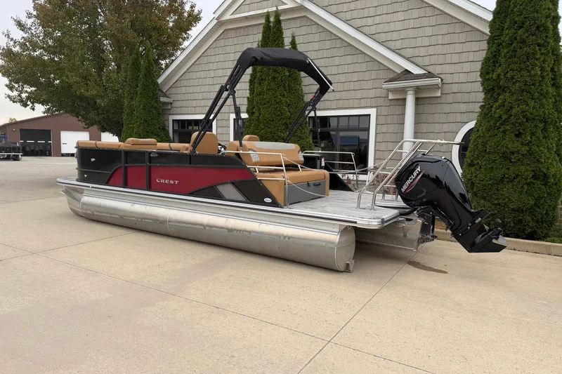 Slide: The Image of 2025 Crest Classic 220 pontoon boat with Mercury engine, parked near a building. - 15