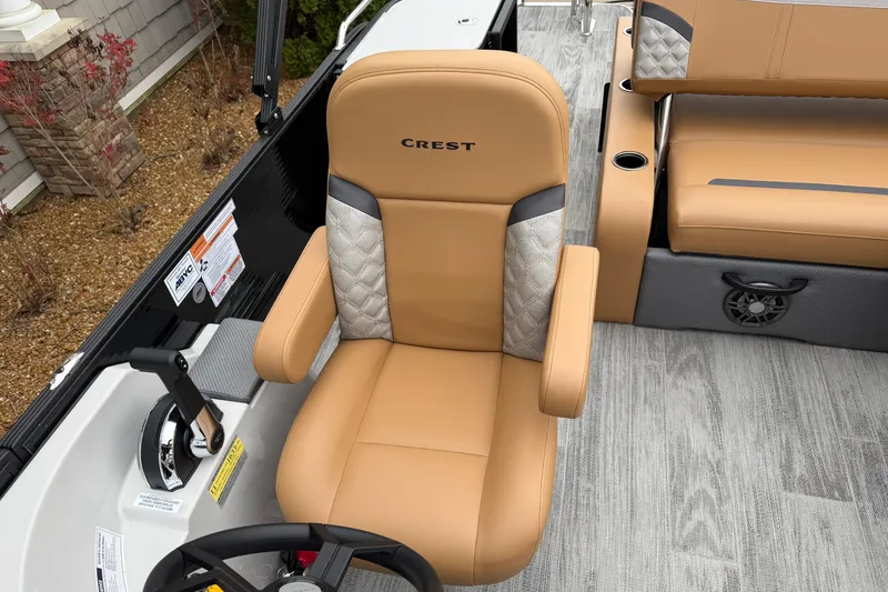 Slide: The Image of 2025 Crest Classic 220 boat interior with tan leather seating and modern controls. - 6