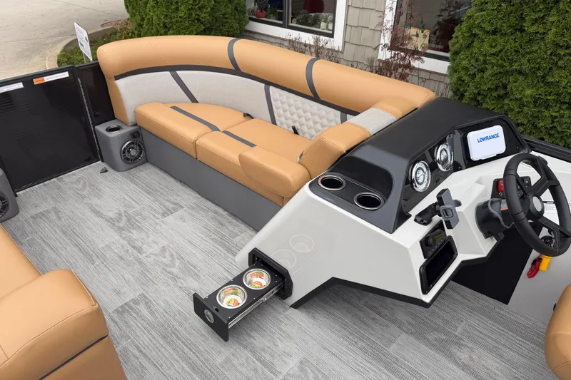 Slide: The Image of 2025 Crest Classic 220 boat interior with tan seating, modern dashboard, and cup holders. - 9