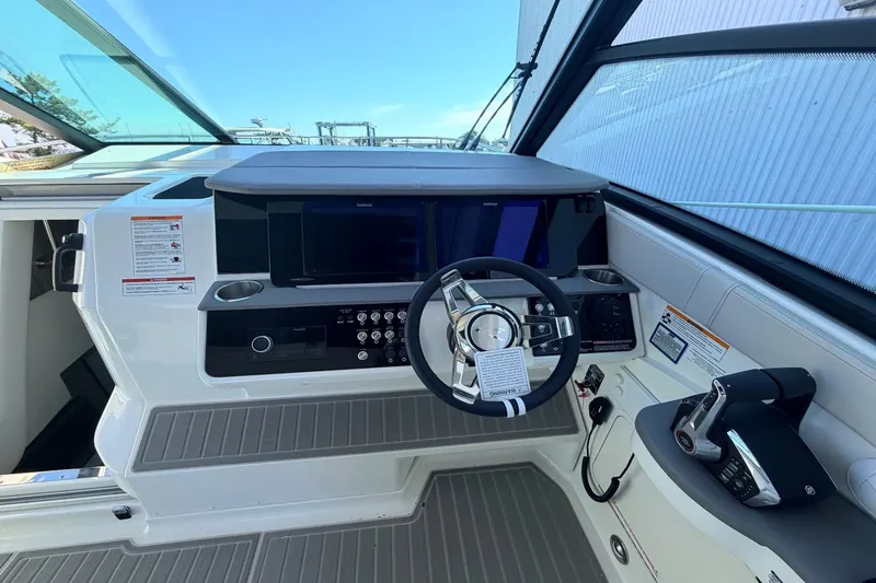 Slide: The Image of The cockpit of the 2026 Sea Ray Sundancer 320 Outboard features a modern helm with multiple screens. - 24