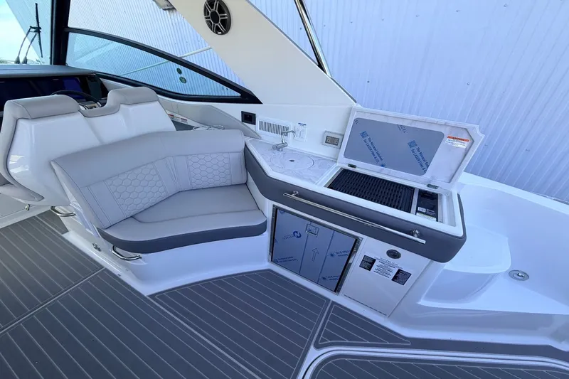 Slide: The Image of The image shows the cockpit of a Sea Ray Sundancer 320 Outboard with sleek seating and a kitchenette. - 19