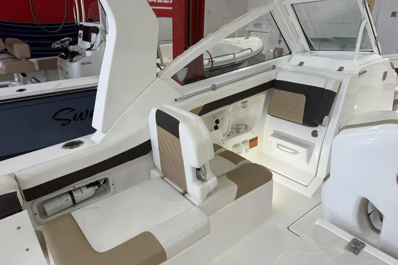 Slide: The Image of 2020 Edgewater 262CX Crossover boat interior with beige and white seating. - 16