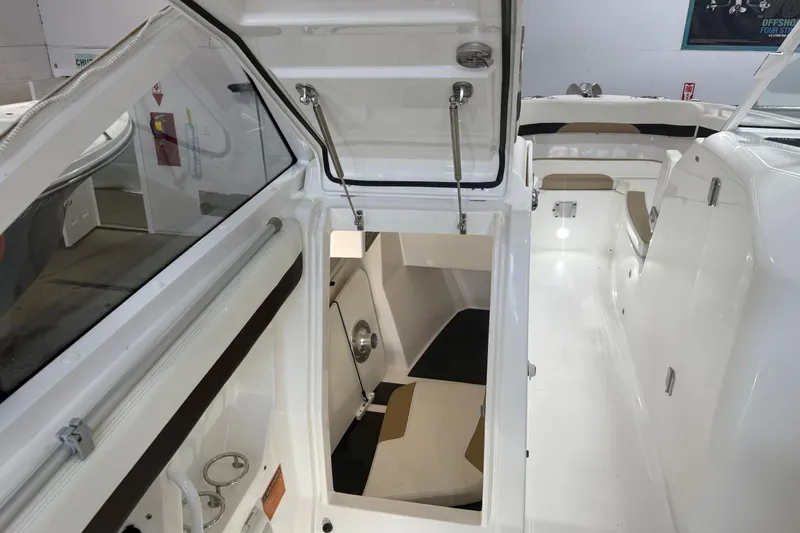 Slide: The Image of 2020 Edgewater 262CX Crossover boat interior with open storage compartment and seating area. - 17