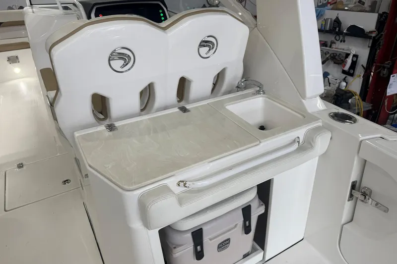 Slide: The Image of 2020 Edgewater 262CX Crossover boat interior with sink and storage area. - 18