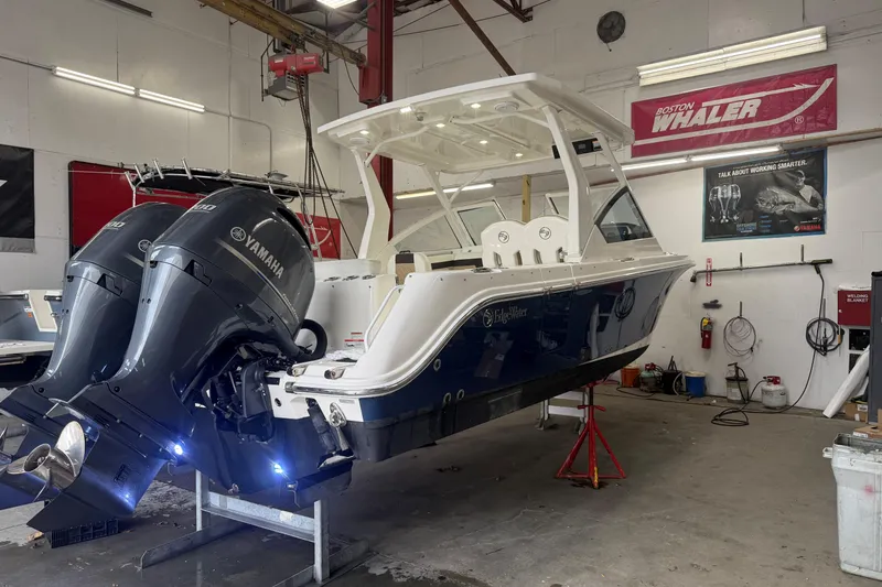 Slide: The Image of 2020 Edgewater 262CX Crossover boat with Yamaha engines in a workshop setting. - 2