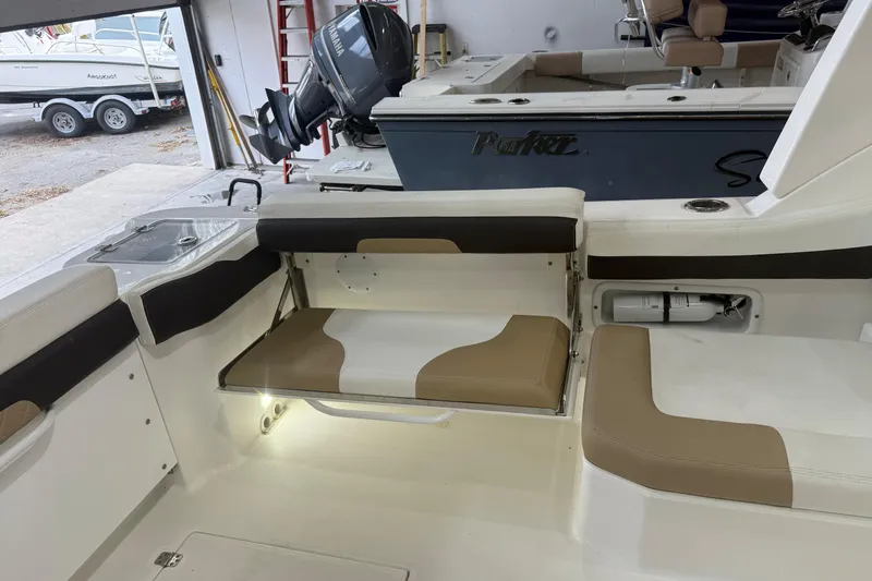 Slide: The Image of 2020 Edgewater 262CX Crossover boat interior with seating and storage compartments. - 20