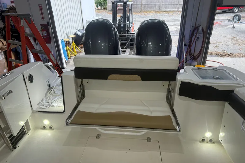 Slide: The Image of 2020 Edgewater 262CX Crossover boat interior with seating and dual engines in a garage. - 22