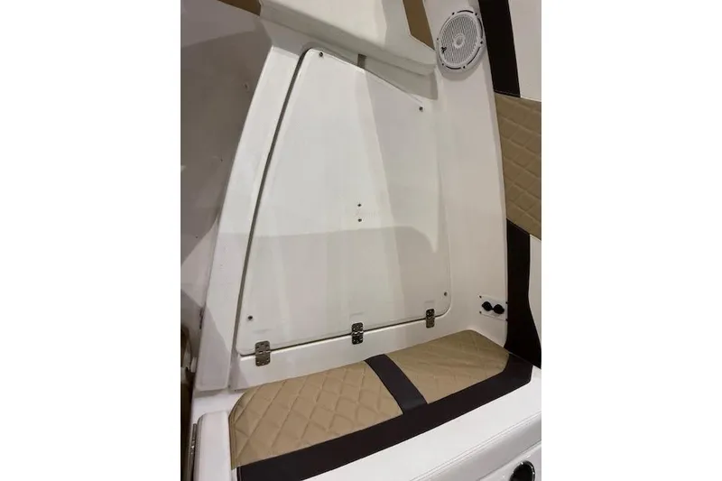 Slide: The Image of 2020 Edgewater 262CX Crossover boat interior with beige quilted seating and speaker. - 25