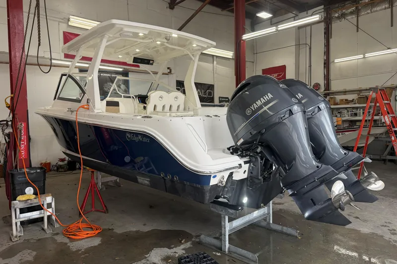 Slide: The Image of 2020 Edgewater 262CX Crossover boat with dual Yamaha engines in a workshop setting. - 4