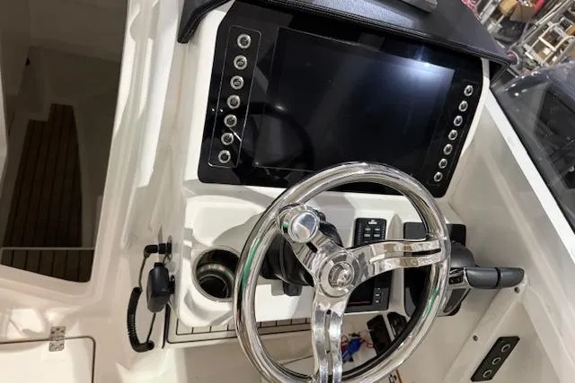 Slide: The Image of 2020 Edgewater 262CX Crossover boat dashboard with steering wheel and control panel. - 9