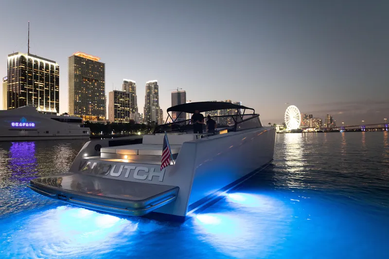 Slide: The Image of VanDutch 55 yacht, 2017 model, illuminated at night with city skyline in the background. - 11