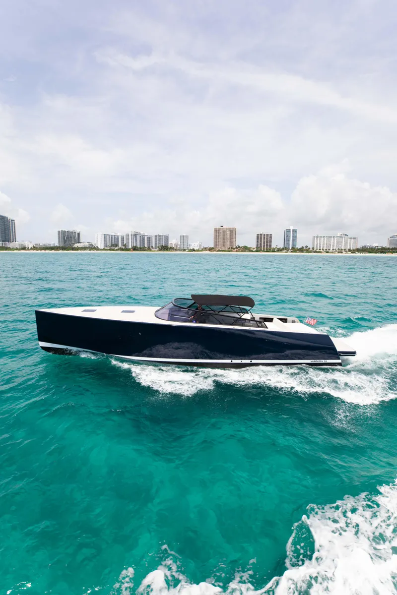 Slide: The Image of 2017 VanDutch 55 yacht cruising on turquoise waters near a city skyline. - 17