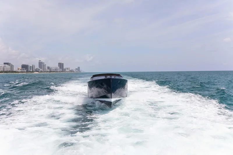 Slide: The Image of VanDutch 55 yacht cruising on open sea, 2017 model, with city skyline in background. - 18