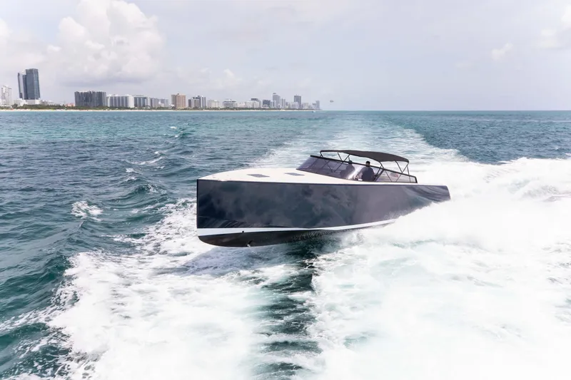 Slide: The Image of VanDutch 55 yacht cruising on open water, 2017 model, with city skyline in background. - 24