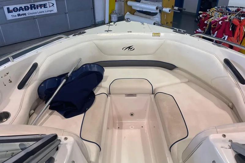 Slide: The Image of 2008 Monterey 214FS boat interior with seating and storage, displayed in a showroom. - 8