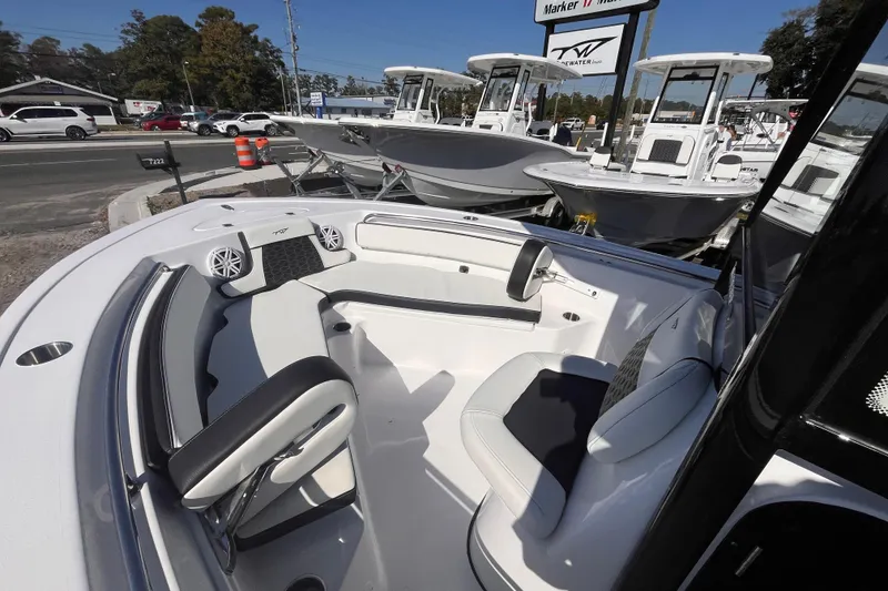 Slide: The Image of 2026 Tidewater 210 LXF boat interior with seating and speakers, displayed at a dealership. - 10