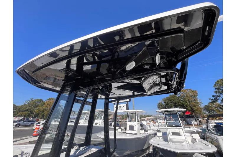 Slide: The Image of 2026 Tidewater 210 LXF boat with sleek T-top design under clear blue sky. - 12