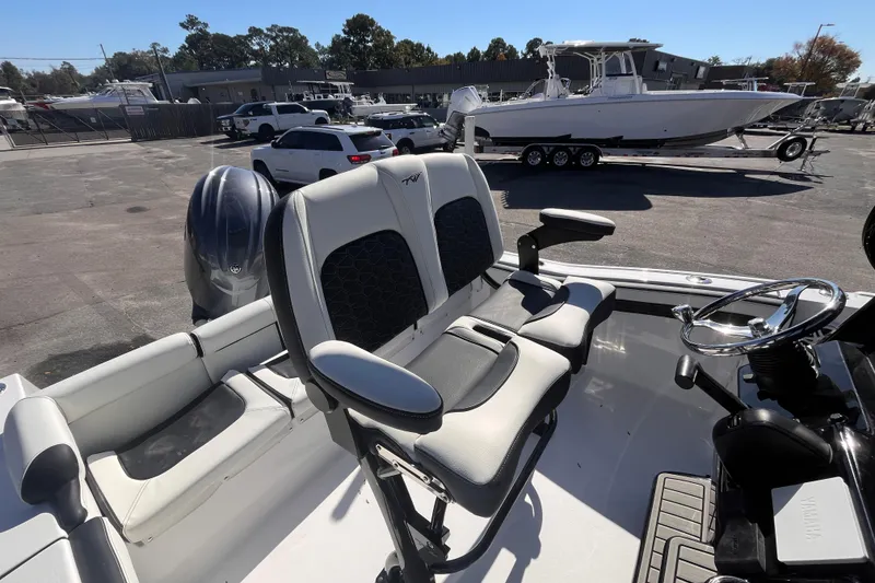 Slide: The Image of 2026 Tidewater 210 LXF boat interior with seating and steering wheel in a marina setting. - 5
