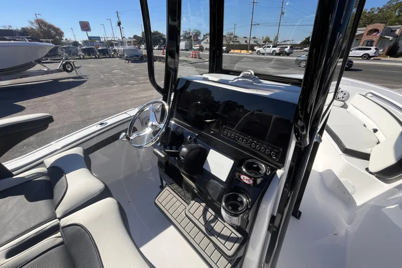 Slide: The Image of 2026 Tidewater 210 LXF boat interior with steering wheel and console, parked outdoors. - 6